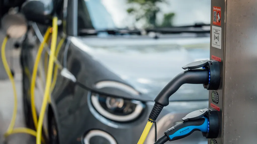 Charging cables plugged into an electric car at a public charger