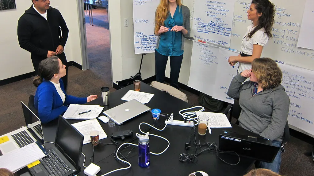 A small team working through notes on a whiteboard in a meeting
